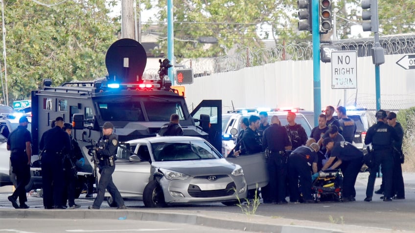 Police cars surround a suspect on an Oakland street