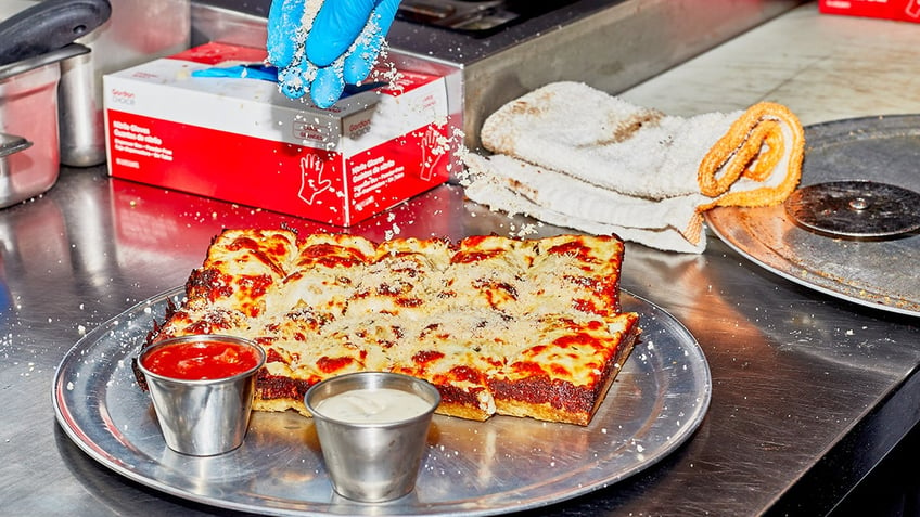 detroit pizza being finished before serving