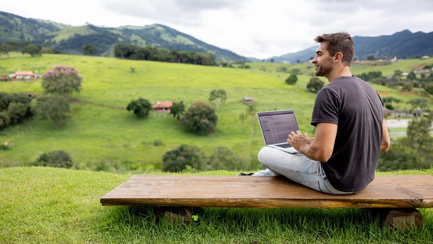 man working on laptop outside