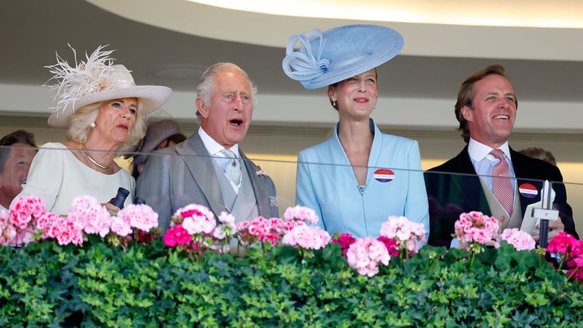 Queen Camilla in white, next to King Charles in a grey suit, Lady Gabriela in blue and Thomas Kingston in a black suit watch Kings Lynn run from their box