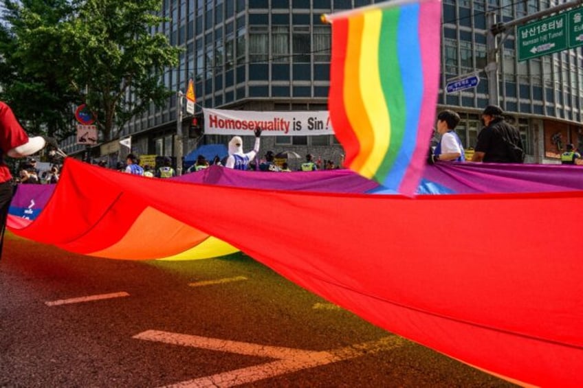 Participants in South Korea's annual Pride parade in Seoul carry a huge flag in support of