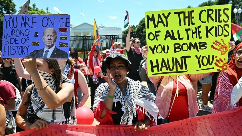 Protesters hold signs