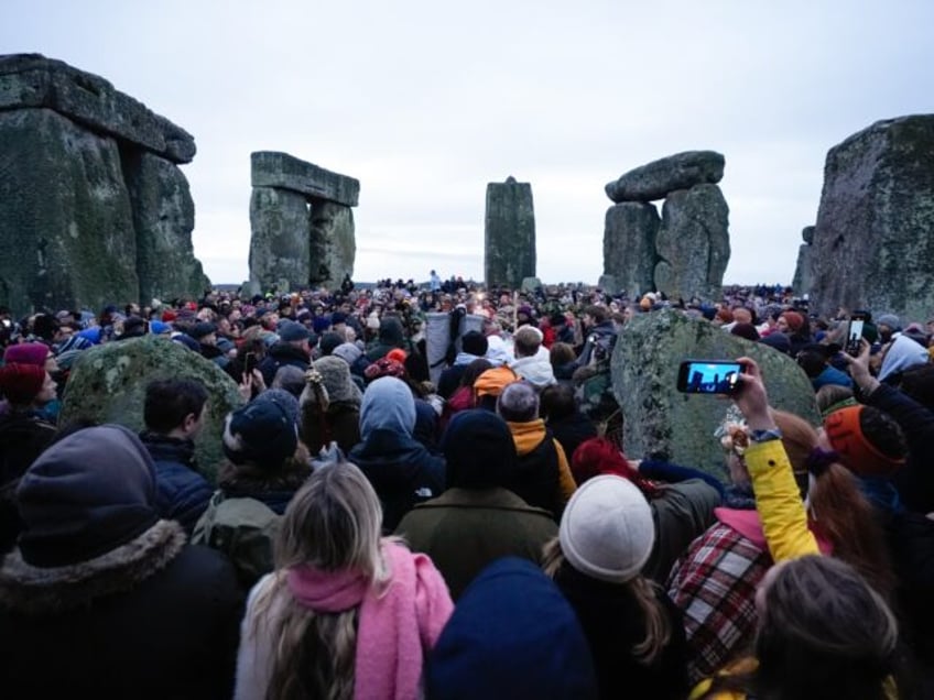 People take part in the winter solstice celebrations during sunrise at the Stonehenge preh