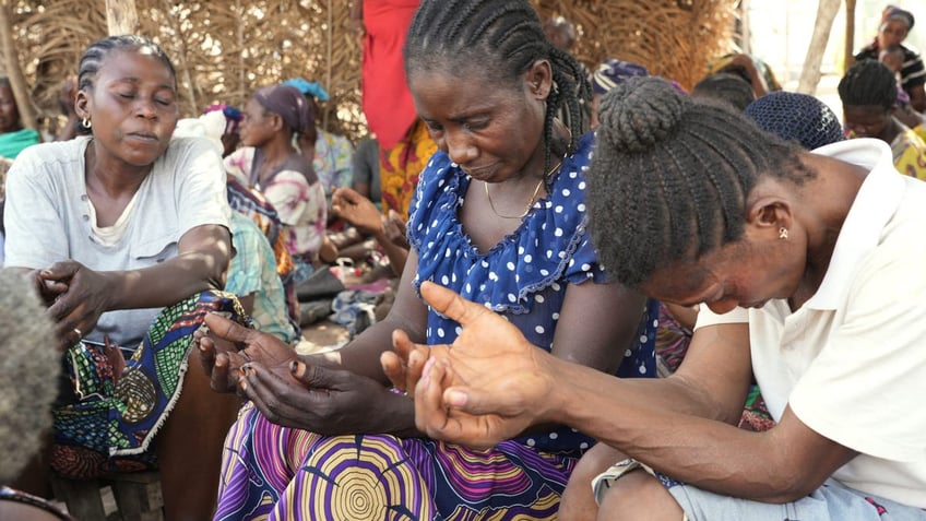 Women are praying at the Benue State Christian Refugee Camp's church.