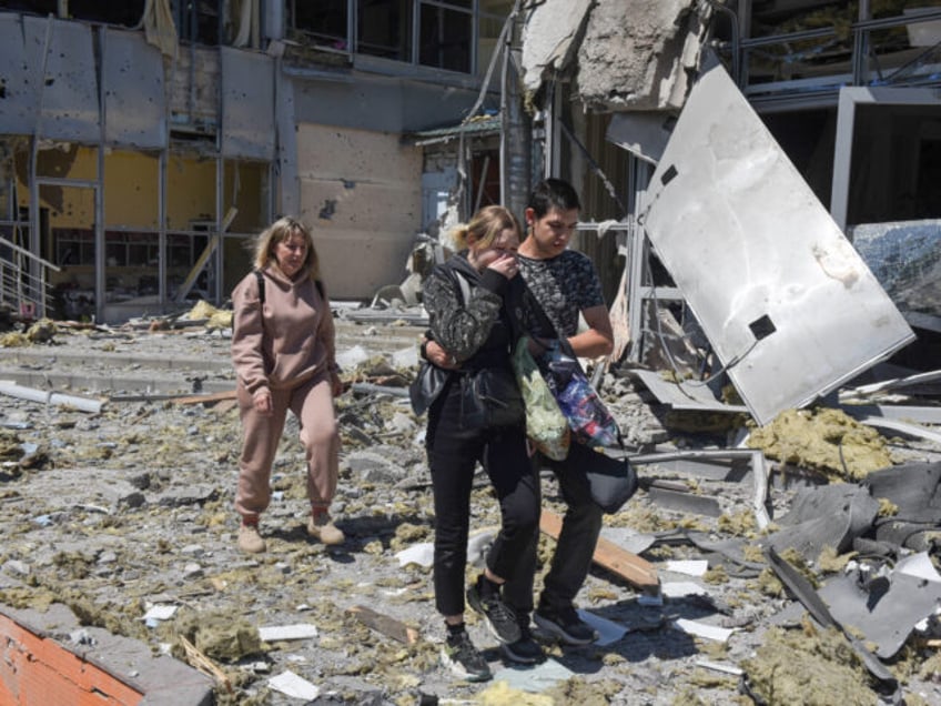 Local residents are seen outside the damaged building housing the Paradise restaurant foll