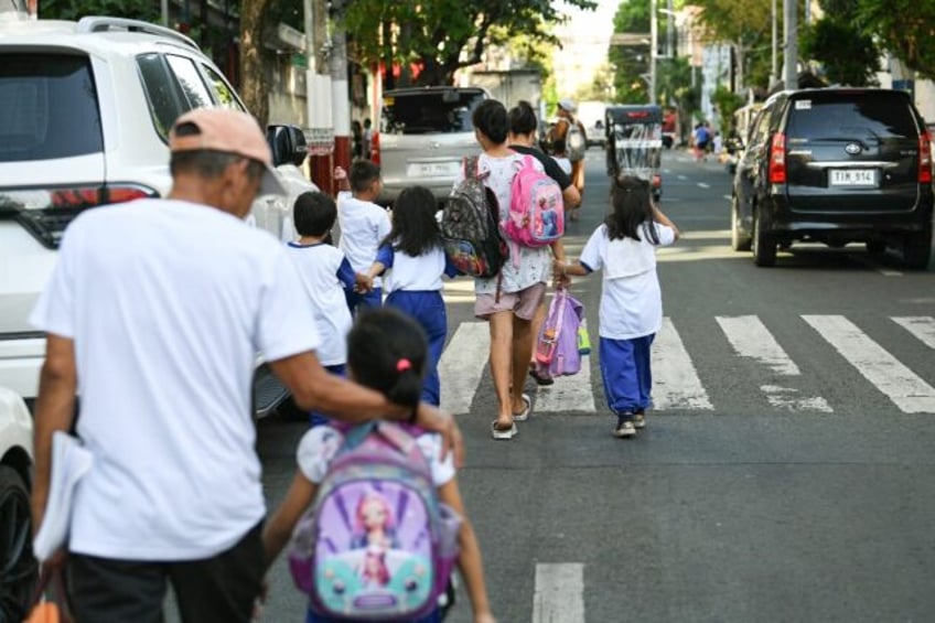 Parents accompany their children from school in Manila after dangerously high temperatures