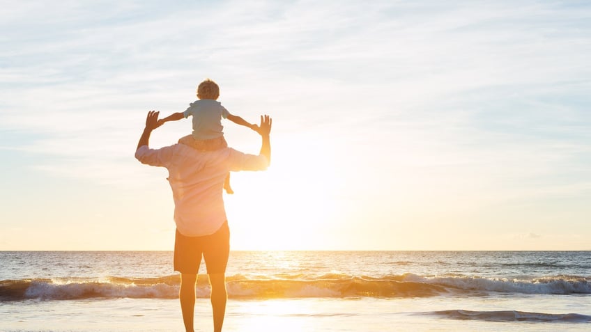 Happy Father and Son Having Fun Playing on the Beach at Sunset. Fatherhood Family Concept