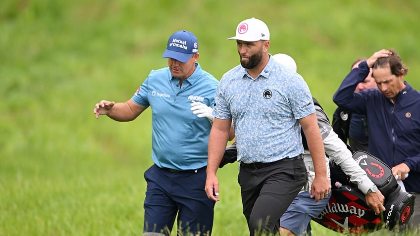 Padraig Harrington walks with Jon Rahm