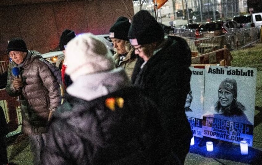 Dwight Yen (L) leads prayers at a vigil for January 6th accused outside the jail in Washington