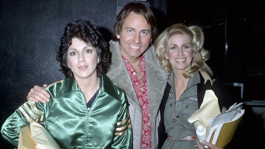 Joyce DeWitt in a green silk blouse is photographed with a smiling John Ritter in a suede jacket and Suzanne Sommers