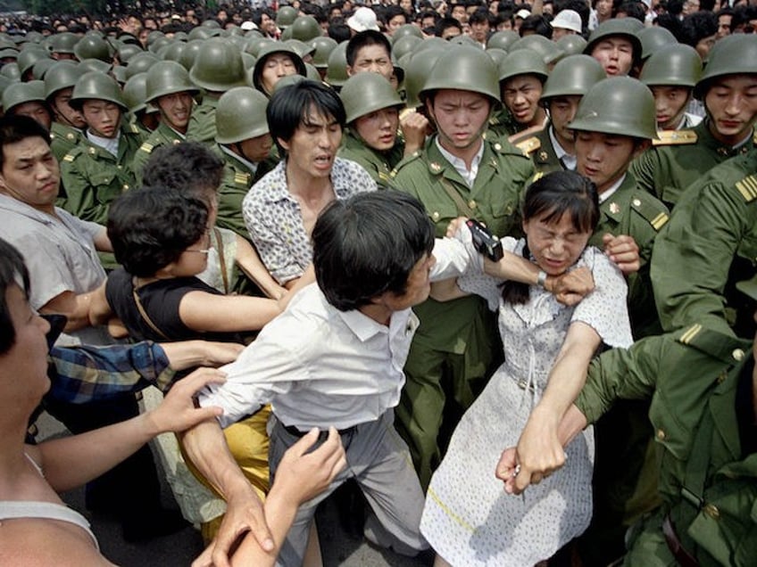 A young woman is caught between civilians and Chinese soldiers, who were trying to remove