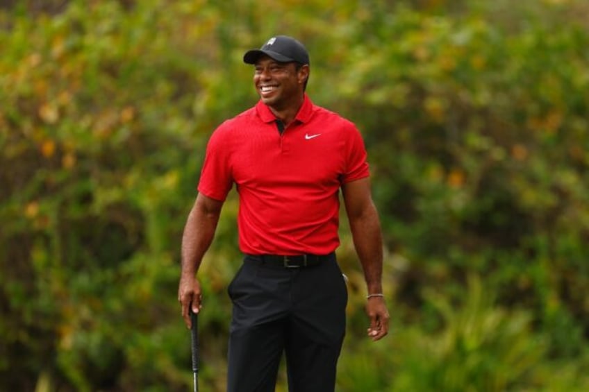 Tiger Woods reacts to a chip-in birdie by his 14-year-old son Charlie on the ninth green during the final round of the PNC Championship