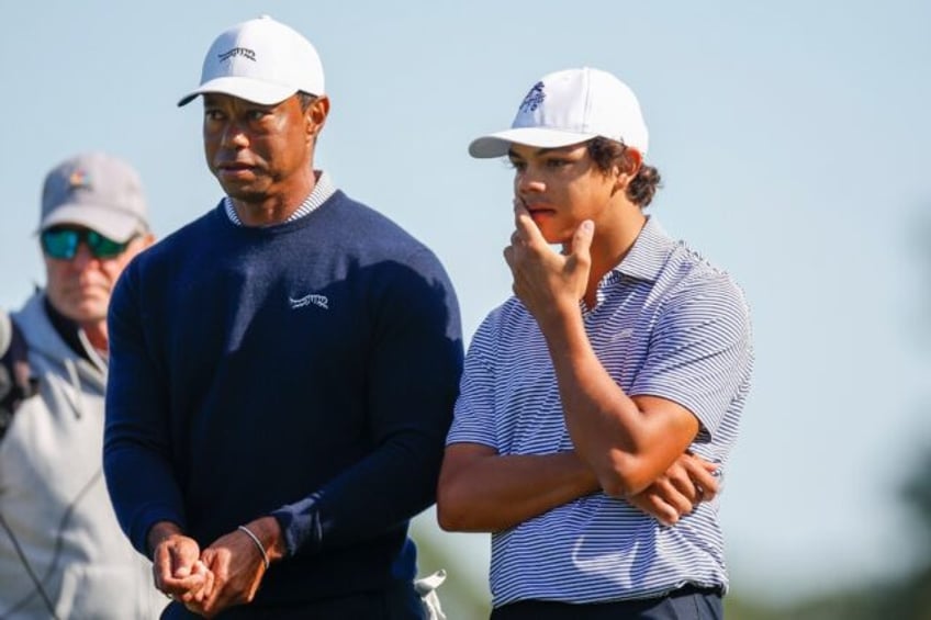 Tiger Woods, left, talks with his son Charlie Woods on their way to grabbing a share of th