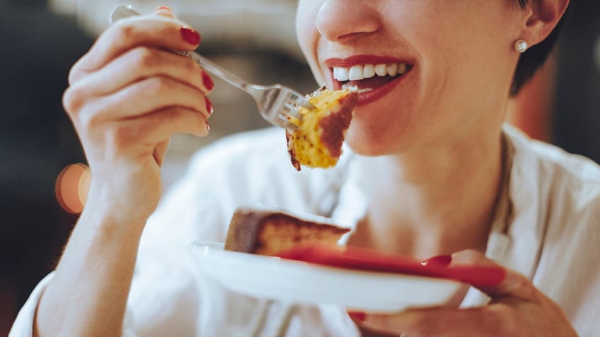 woman smiling eating dessert