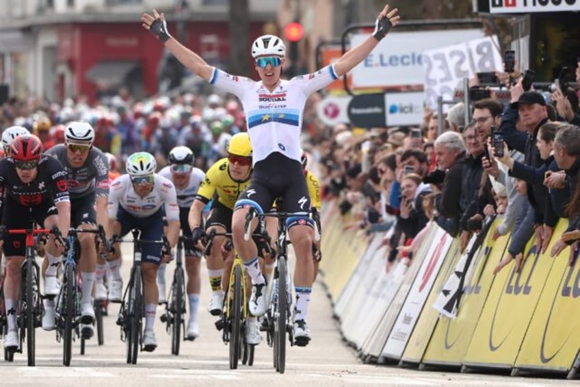 Tim Merlier (C) celebrates as he crosses the finish line at Le Perray-en-Yvelines to win t