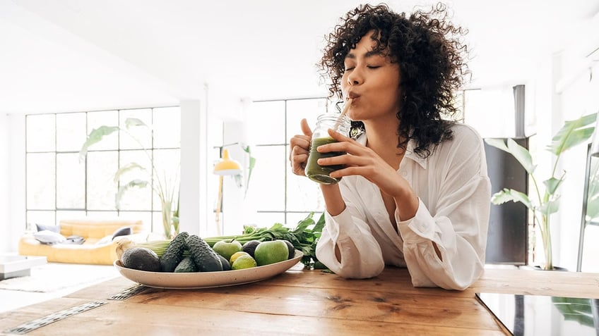 woman drinking green juice health and fitness