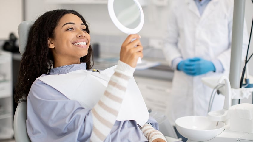 woman checks out her teeth at the dentist