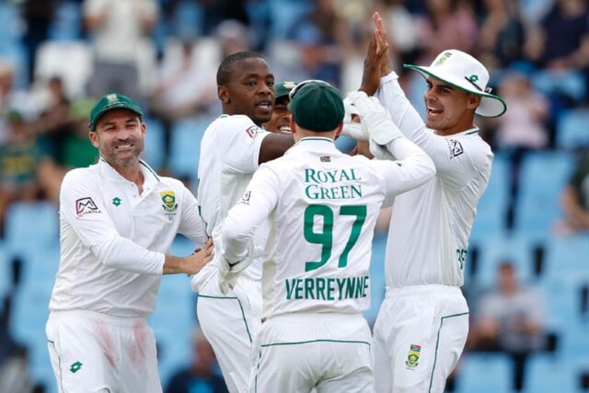 South Africa's Kagiso Rabada (2nd L) celebrates with teammates on the opening day of the first Test against India at Centurion