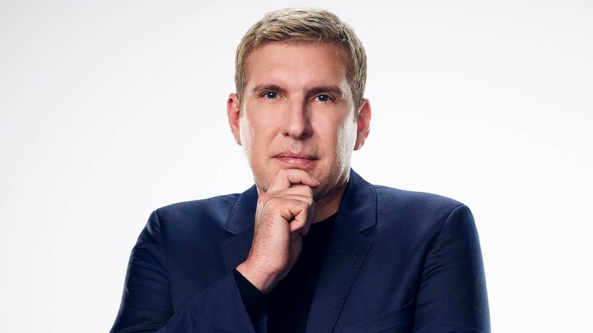 todd chrisley with his hand on his chin