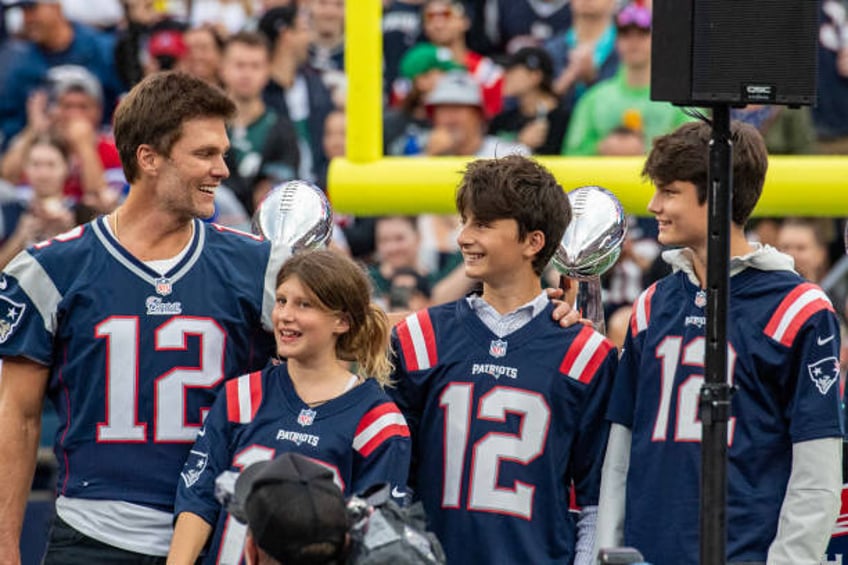 Tom Brady stands with his children during a "Thank You" celebration honoring the former New England Patriots' quarterback during half time of the...