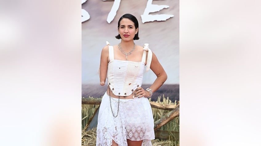 Victoria Canal wearing a strapped white top and a matching white skirt on the red carpet.