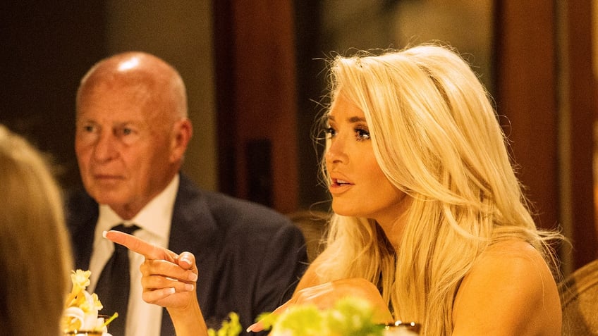 Erika Jayne points her finger next to Tom Girardi at a party on RHOBH