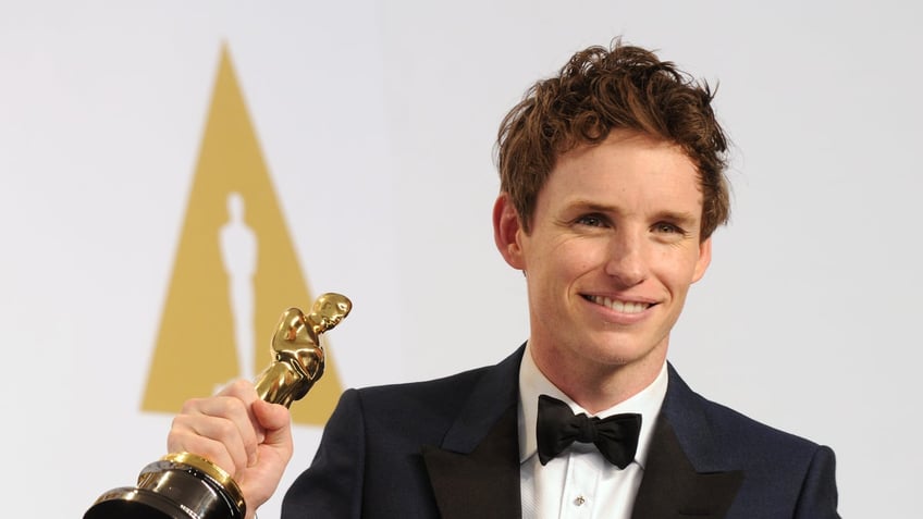 Eddie Redmayne holding Oscar statue