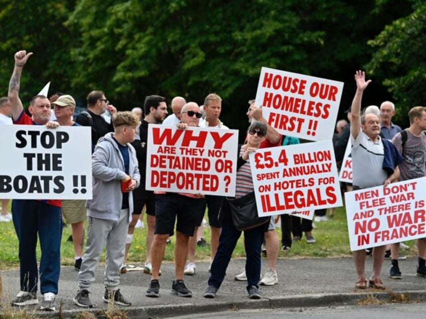 Protesters hold placards during a 'Enough is Enough' demonstration called by far-right act