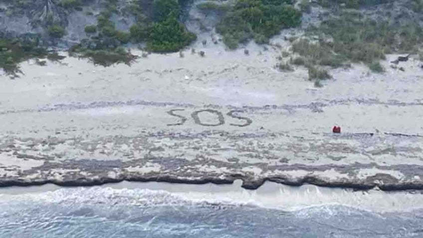 SOS written in sand on beach