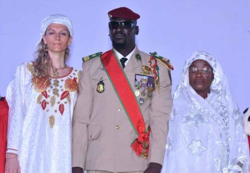 Guinea junta leader Colonel Mamady Doumbouya poses with his wife (L) and mother at his swe