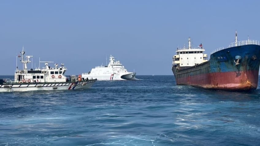 Two Taiwan Coast Guard personnel board a Togo-flagged a cargo ship