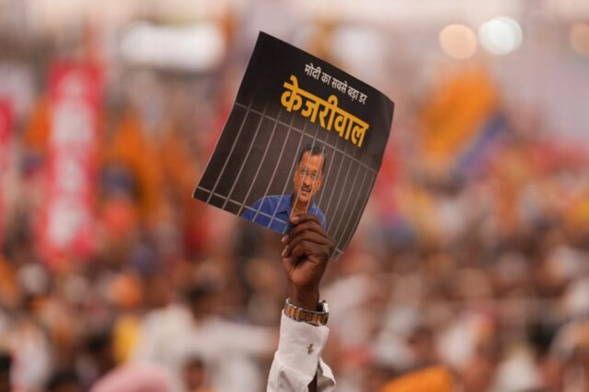 Indian protesters hold a placard of jailed Delhi Chief Minister Arvind Kejriwal during a r