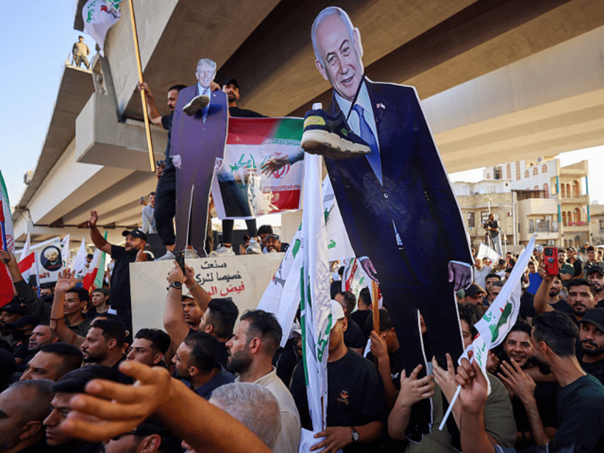 Supporters of Iraqi pro-Iran groups hold a cutout of US President Donald Trump and Israeli