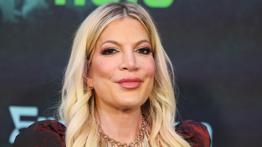 Tori Spelling soft smiles/pouts on the carpet in Los Angeles