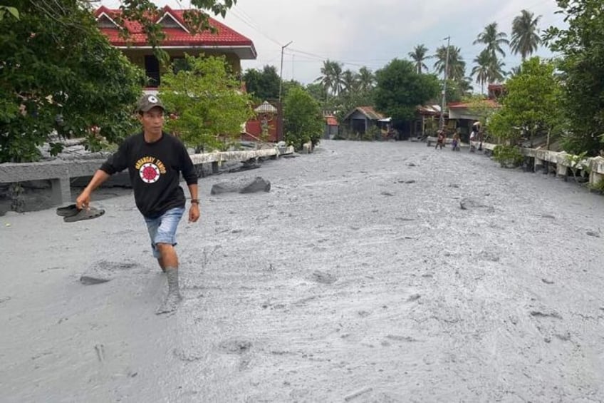 Volcanic mud and debris washes through a village in the central Philippines after Mount Ka