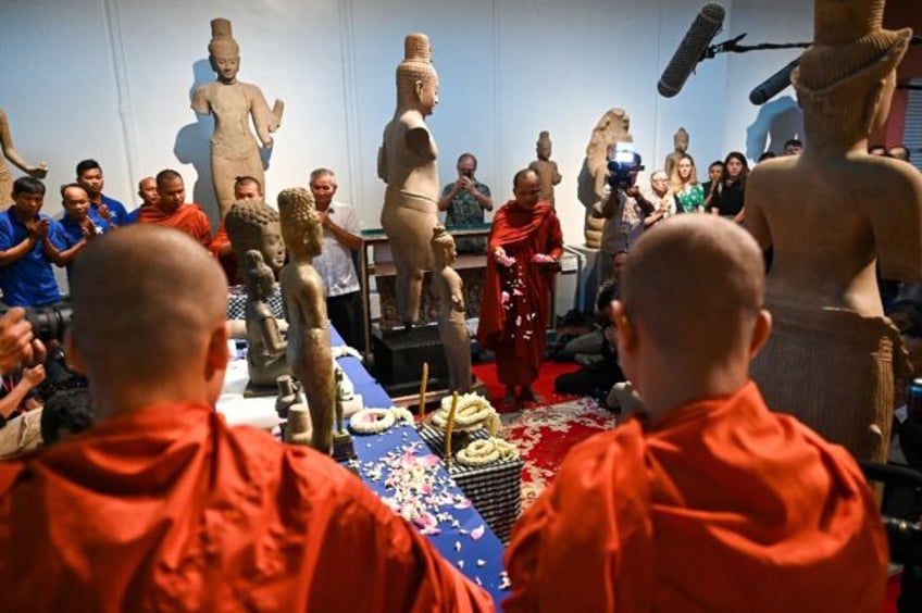 Buddhist monks chanted blessings and threw flowers to welcome the artefacts back to Cambod