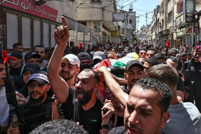 Pallbearers carry the body of Palestinian militant Wael Masha through the streets of Balat