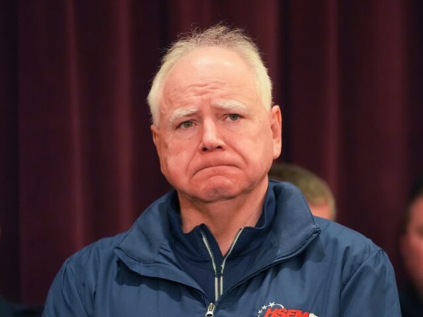 Minnesota Gov. Tim Walz stands at a press conference after two police officers and a first