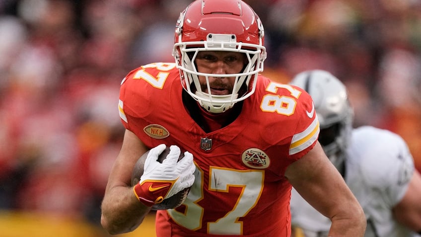 Travis Kelce runs wit the ball