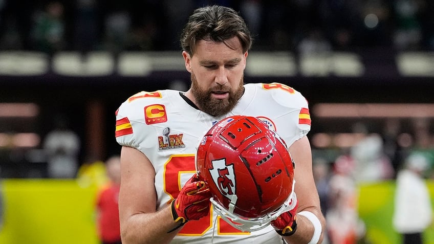 Travis Kelce adjusts his helmet