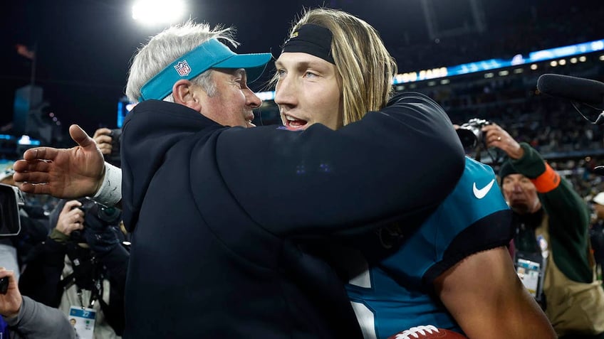 Head coach Doug Pederson and Trevor Lawrence embrace after the wild card round