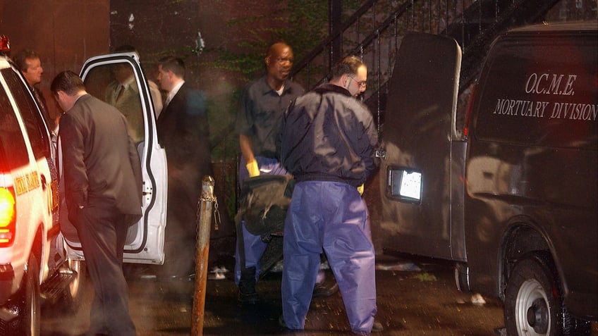 Officials carry Jam Master Jay's body out of the recording studio where he was killed