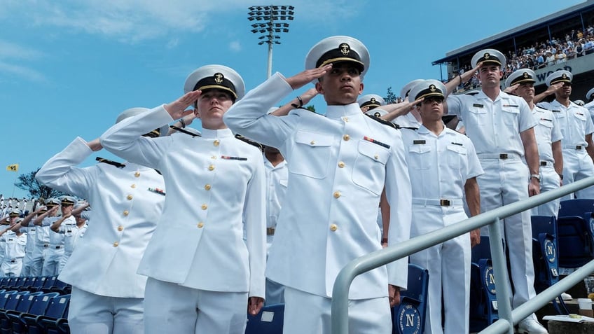 Midshipmen render a salute during the commissioning and graduation ceremony at the U.S. Naval Academy in Annapolis, Maryland, on May 24, 2024.