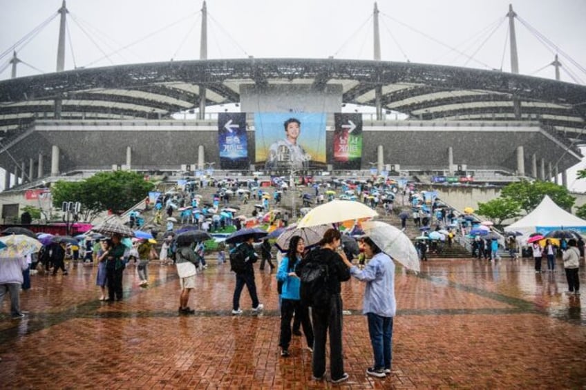 South Korean fans brave the rain as they arrive for a concert by trot singer Lim Young-woo