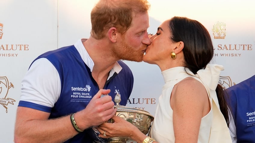 Prince Harry and Meghan Markle share a kiss after a charity polo match.