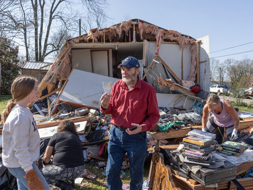 CALERA, ALABAMA - MARCH 16: Tim Striegel goes though his damaged belongings and finds a si