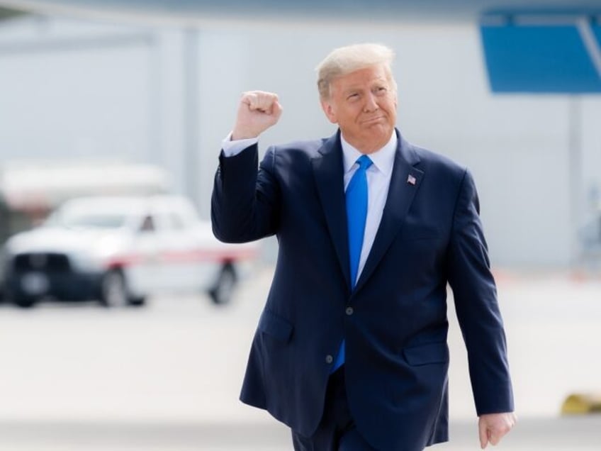 President Donald J. Trump gestures with a fist pump as he walks across the tarmac upon his