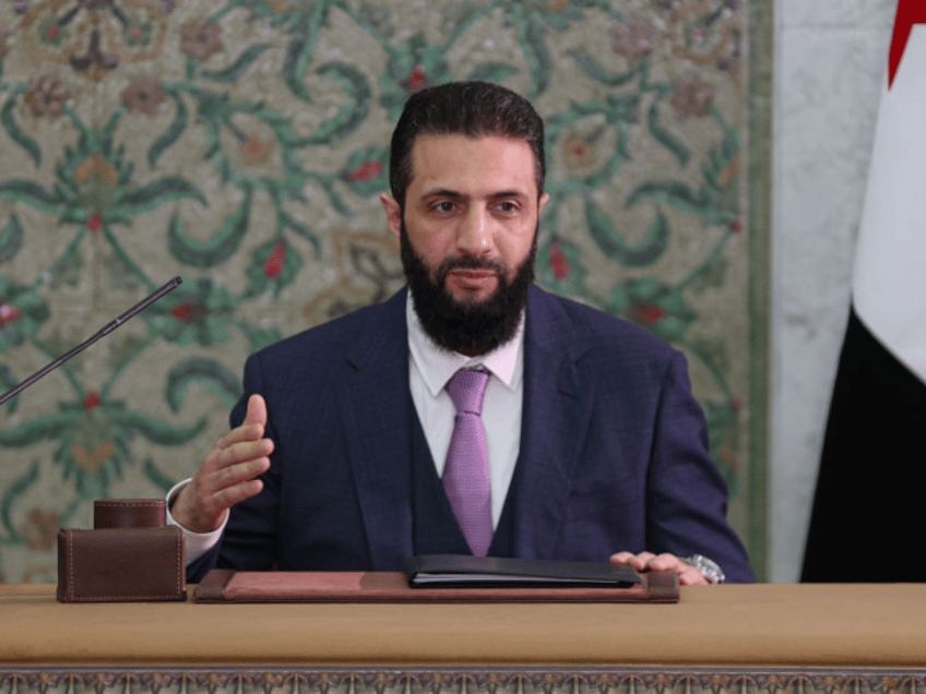 DAMASCUS, SYRIA - MARCH 13: Syrian President Ahmed al-Sharaa signs a declaration outlining