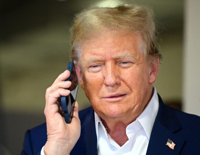 MIAMI, FLORIDA - MAY 05: Donald Trump talks on the phone in the McLaren garage prior to th