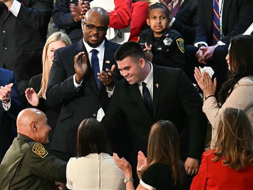 Jason Hartley (C) stands after US President Donald Trump announced that Hartley has been a